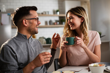 Husband and wife enjoying in breakfast. Loving couple drinking coffee in the kitchen.