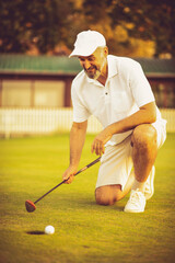 The golfer waits for the ball to enter the hole.