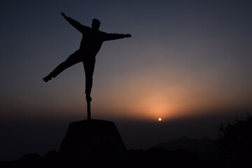 Picture of a boy standing on a iron pole.Design like a star. sunset in background. Selective focus, Selective Focus On Subject, Background Blur
