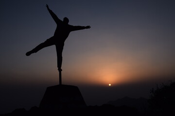 Picture of a boy standing on a iron pole.Design like a star. sunset in background. Selective focus, Selective Focus On Subject, Background Blur