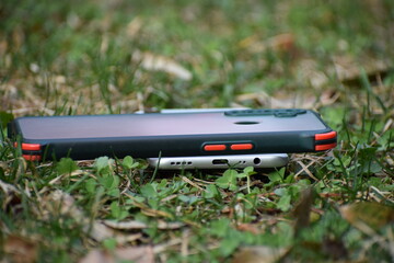 Beautiful picture of a mobile and mobile cover in green grass. Selective focus, Selective Focus On Subject, Background Blur