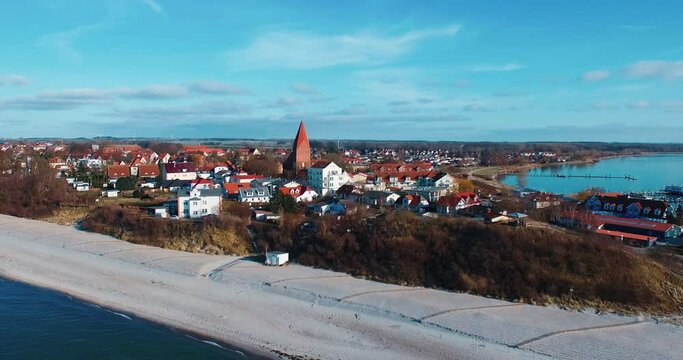 small village at the sea with pine fly over blue sky and water aerial church drone 4k