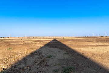 two man jumping from thar jeep and behind is windmill in jaisalmer area of rajasthan.