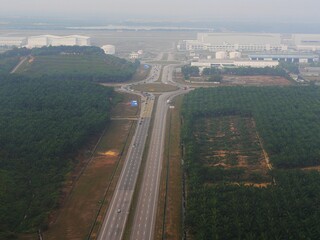 Palm tree plantations and highways seen from an airplane window approaching Kuala Lumpur, Malaysia.