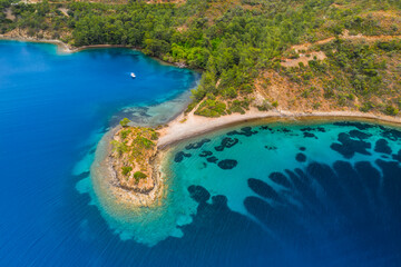 Fototapeta premium Aerial view of clear turquoise water near the rocky coast of the Aegean Sea, Turkey.