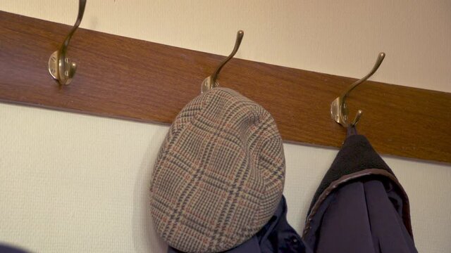 Coat and hat taken of and on a coat hook on a rack