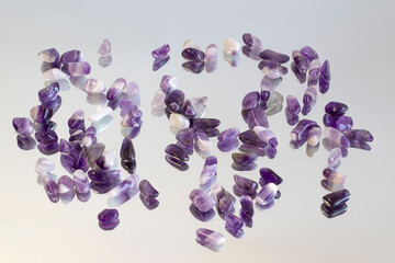 Set of various amethyst natural mineral stones and gemstones on mirror Narrow focus line, shallow depth of field