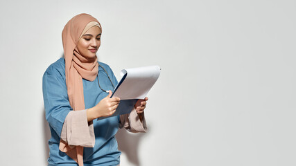 Happy young arabian woman doctor looking into notepad