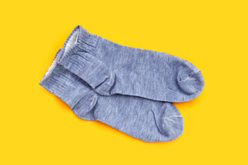 Grey socks on yellow background.