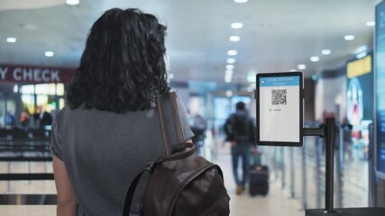 vaccine passport tourist shows covid-19 certification at the airport check in zone,woman scanning coronavirus travel vaccination certificate at the departure area,green card pass - Powered by Adobe