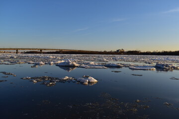 Early spring. Beautiful evening landscape with views of the ice drift on the river and the bridge.
