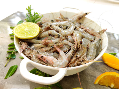 Fresh White Prawns decorated in a white bowl with herbs and fruits.Selective focus.