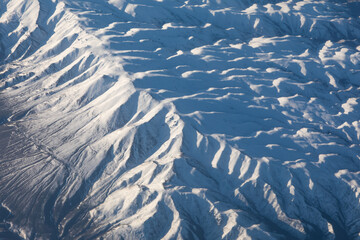 Aerial view of snowy mountains, top view of winter landscape