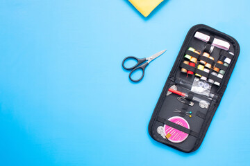 Sewing and objects for sewing on blue background.