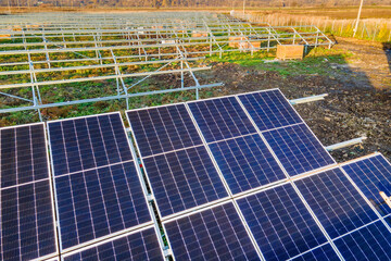 Solar power plant under construction on green field. Assembling of electric panels for producing...