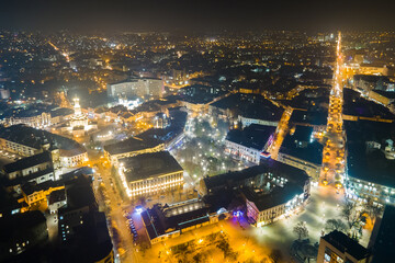 Obraz premium Aerial view of bright illuminated streets and buildings in Ukrainian Ivano-Frankivsk city center at night.