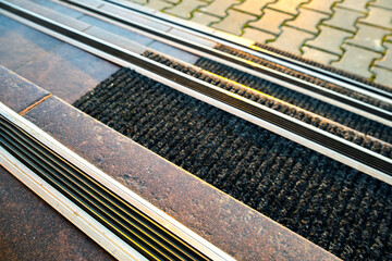 Closeup of ceramic tiles covering porch stairs with rubber anti slippery stripes on it.