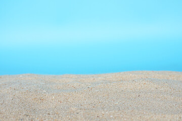 Fototapeta na wymiar Sea beach sand texture on blue background with selective focus. Summer background concept. 