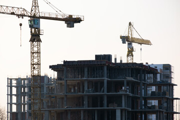 Tower cranes and high residential apartment buildings under construction. Real estate development.