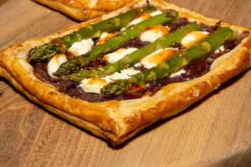 A delicious Asparagus, Caramelised Onion and Goats Cheese Galette on a wooden kitchen table