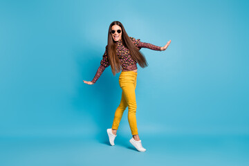 Full size photo of young beautiful cheerful funky positive smiling woman dancing with sunglasses isolated on blue color background