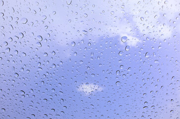 Rain drops cling to the car windows on a rainy day Blurred background blue sky
