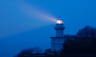 Lights in the lighthouse with fog at dawn, Igueldo, city of Donostia (San Sebastian)