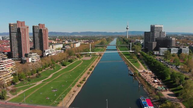 Top view of the embankment of the Neckar River. Bridges, TV tower, green grass and trees. Hospital, tram lines. Mannheim. Germany.