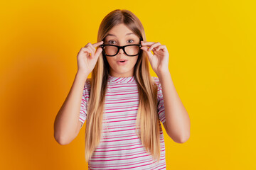 Shocked girl pull glasses down isolated on yellow background