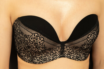 Young caucasian woman wearing black lace lingerie, without strapless