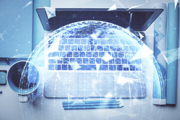 Business theme hologram drawings over computer on the desktop background. Top view. Multi exposure....