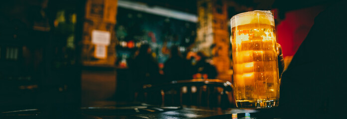 man hold a glass of beer in his hand at the bar or pub