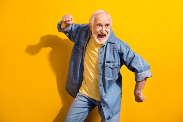 Portrait of excited positive person look empty space open mouth smile dancing isolated on yellow color background