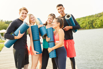 Gruppe Freunde mit Yogamatte lachen fröhlich