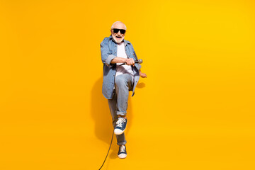 Full length body size of grandfather in sunglass dancing keeping microphone on festival isolated...