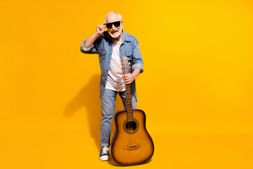 Full length photo of optimistic cool grey beard old man hold guitar wear spectacles shirt isolated on orange background