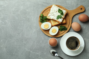 Fototapeta na wymiar Concept of tasty breakfast with boiled eggs on gray textured table
