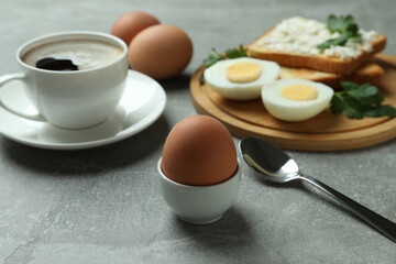 Concept of tasty breakfast with boiled eggs on gray textured table