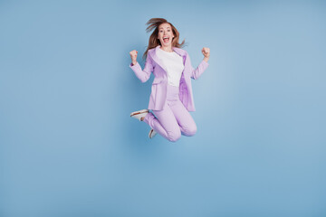 Photo of crazy girl jump win raise fists isolated over blue background