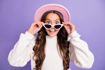 Photo of young amazed girl shocked surprised news sale hands touch sunglass isolated over purple color background