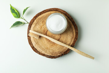 Board with eco friendly toothbrush and tooth powder on white background