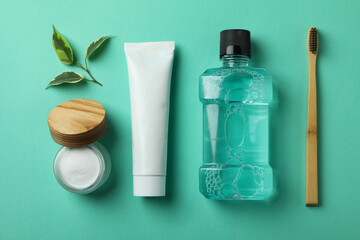 Oral care accessories on mint background, top view