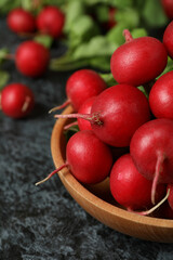 Bowl with fresh radish on black smokey table