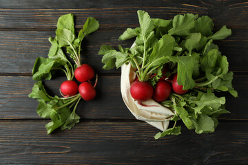 Bag with radish on wooden background, top view