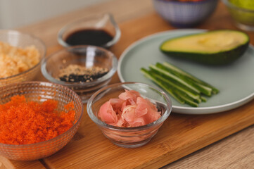 Still life ingredients for making sushi. Master is serving fresh delicious rolls on the wooden board