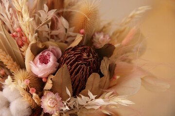 Bouquet of dry flowers and leaves on blurred background, closeup