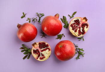 Flat lay composition with ripe pomegranates on violet background