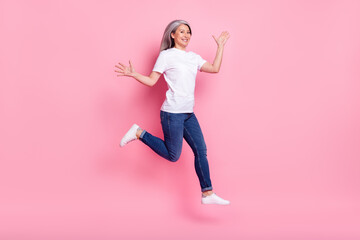 Full length body size photo of elder woman jumping high cheerful positive isolated pastel pink...