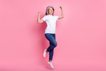Fototapeta na wymiar Full length body size photo of woman jumping up gesturing like winner isolated pastel pink color background