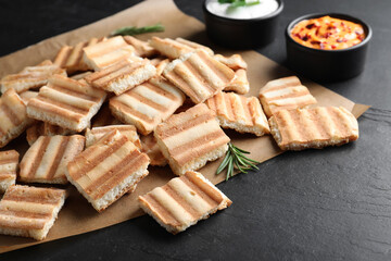Delicious pita chips and sauce on black table